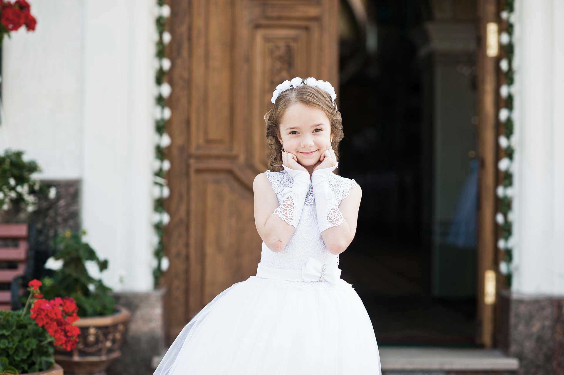 bambina fuori la chiesa con abito comunione