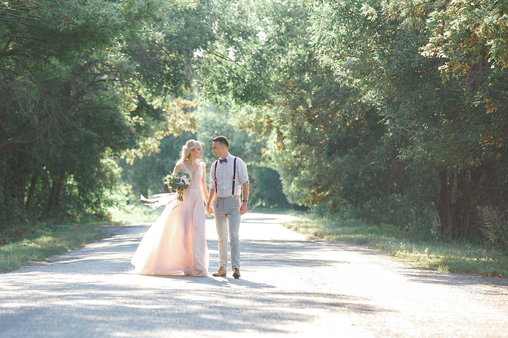 coppia di sposi a passegio in un viale alberato
